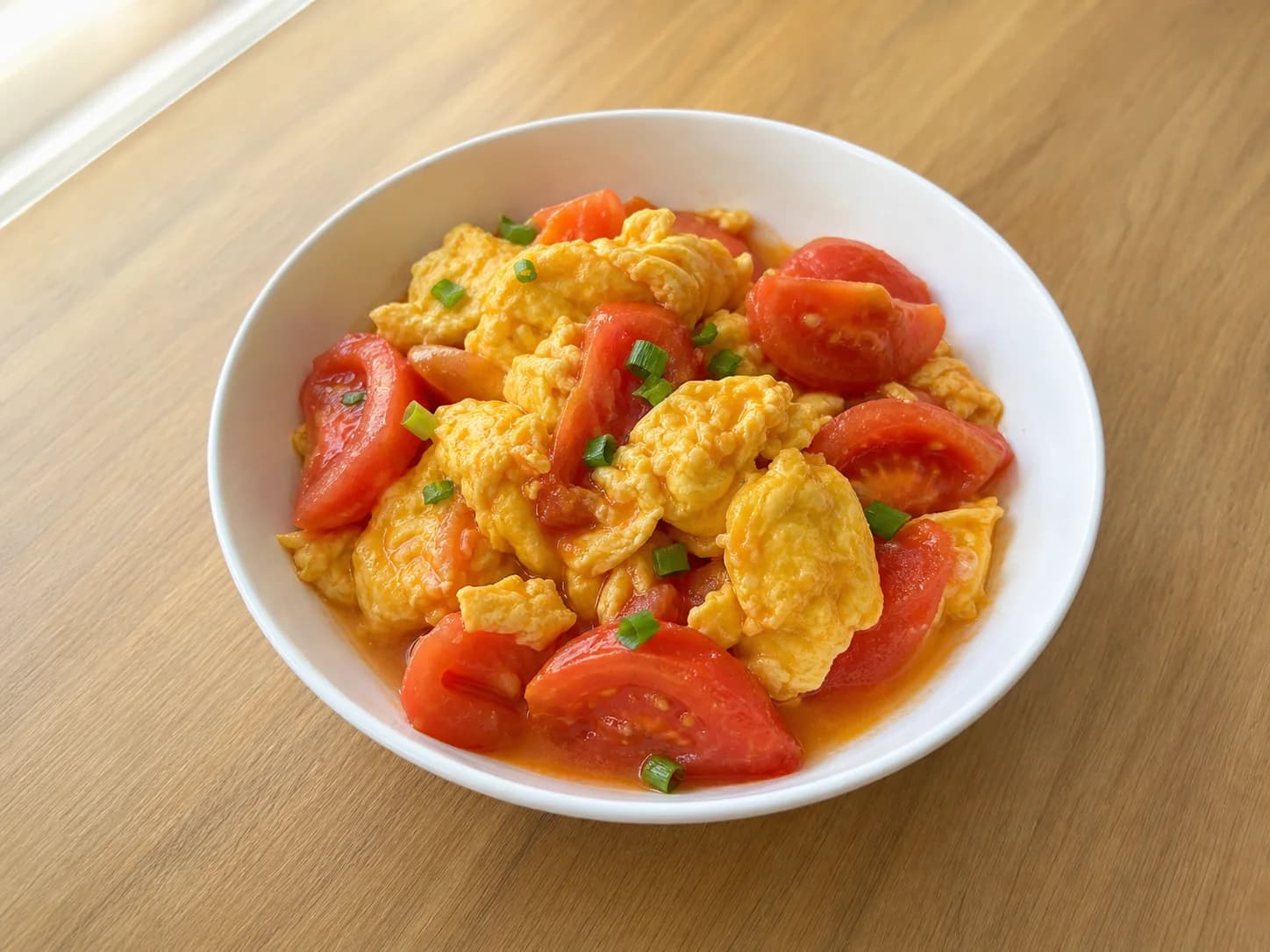 Tomato scrambled eggs in a white ceramic bowl